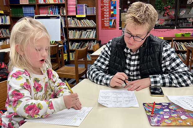 Teen assistant Clay McIlnay tutoring a student